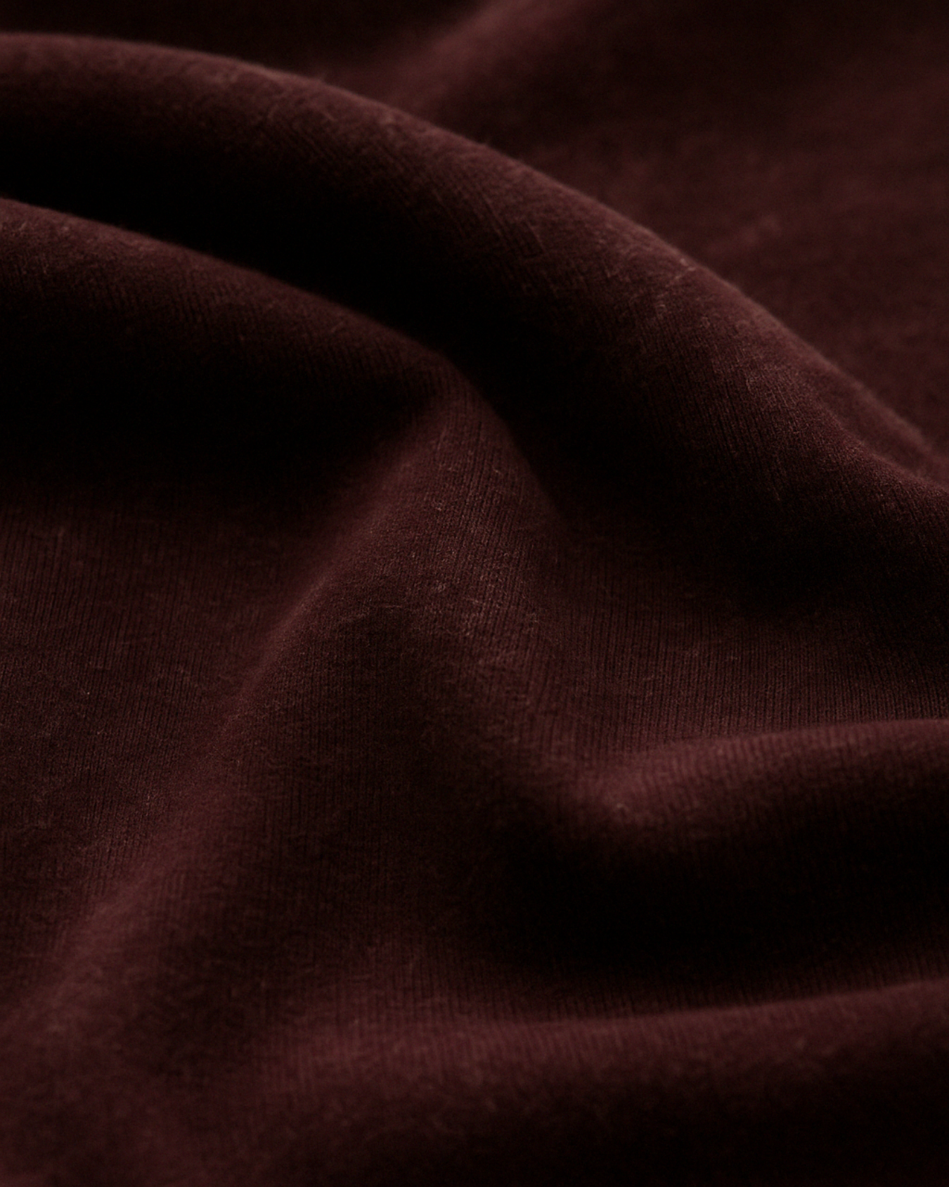 Closeup of maroon acid wash fabric – soft texture, premium cotton knit
