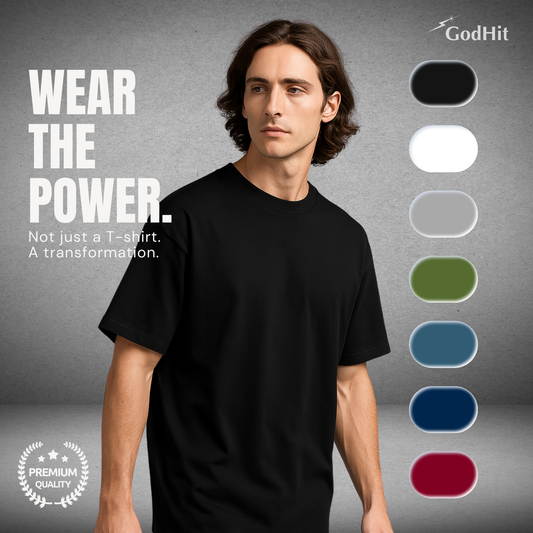 Male model wearing GodHit black oversized T-shirt standing confidently with color swatches on side and text “Wear the Power – Not just a T-shirt. A transformation.