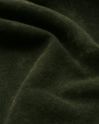 Textured closeup of olive green acid-wash cotton fabric – authentic look